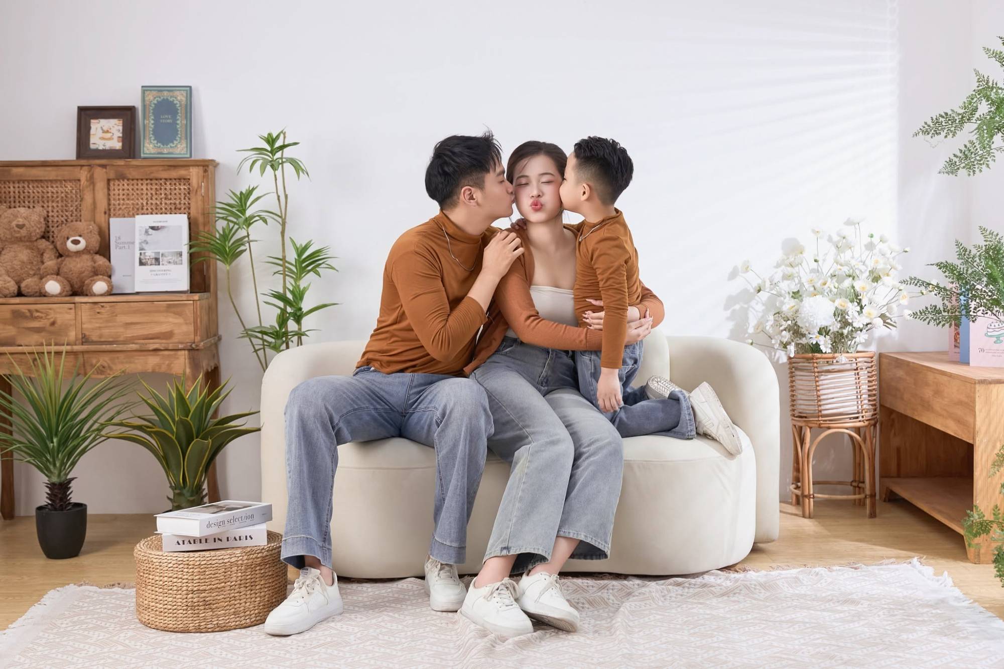 Bố và con trai cùng hôn má mẹ trên sofa