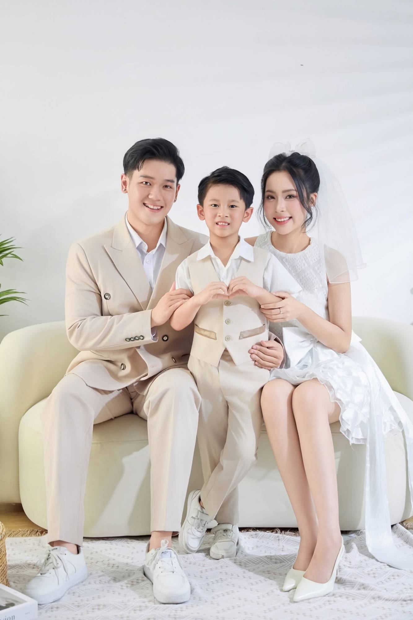 Gia đình tông be trên sofa, bé tạo hình trái tim